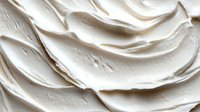 Creamy white frosting swirls with smooth texture and flowing curves for cake decoration and dessert design projects.