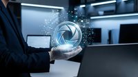 Businessman in dark suit holding glowing aperture symbol with digital particles in modern office environment, representing photography, technology, and creative innovation.