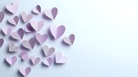 Delicate pink paper hearts scattered on light background creating soft romantic composition with gentle shadows, suitable for Valentine's Day designs and love themes.