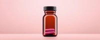 Brown glass medicine bottle with pink pills on pink background. Pharmaceutical container for medical supplements, vitamins or prescription drugs. Clean minimal composition.