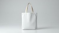 White cotton tote bag mockup with natural handles on neutral background for branding and promotional design projects.