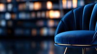 Elegant navy blue velvet armchair with gold legs in modern luxury interior with warm bokeh lighting for sophisticated home decor and furniture design.