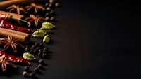 Aromatic spices and seasonings arranged on dark background with copy space for culinary designs and cooking projects.