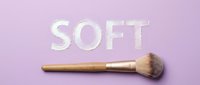 Makeup brush with soft bristles on pastel purple background with embossed text, suitable for beauty, cosmetics, and skincare design projects.