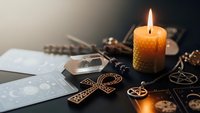 Mystical tarot cards with burning candle and occult symbols creating atmospheric fortune telling scene for spiritual guidance and divination practices.
