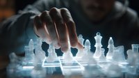 Glass chess pieces on illuminated board with player's hand making strategic move in dramatic lighting, creating mystical atmosphere for business strategy concept.