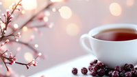 Cozy tea time with white cup of hot tea, dried cranberries and decorative branches with warm bokeh lights creating peaceful morning or evening atmosphere.