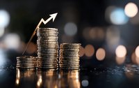 Stacks of silver coins with upward arrow showing growth trend against dark background with bokeh lights, representing financial success and investment gains.