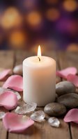 White candle burning surrounded by pink rose petals and smooth stones on wooden surface creating peaceful spa atmosphere for relaxation and wellness.