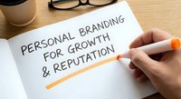 Professional development concept with hand writing personal branding for growth and reputation on paper at wooden desk with coffee and glasses.