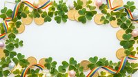 St. Patrick's Day frame with shamrock leaves, gold coins and Irish flag ribbons on white background for festive holiday greeting cards and decorations.
