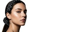 Young woman with olive complexion and long dark hair styled with decorative pearl-adorned headpiece, wearing minimal makeup with natural skin texture, suitable for beauty and fashion editorial use.