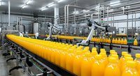 Industrial orange juice production line with robotic automation in modern beverage manufacturing facility for food processing operations.