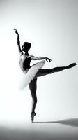Graceful ballerina in white tutu performing arabesque on pointe in dramatic black and white studio lighting for dance and performing arts concepts.