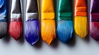 Row of vibrant paintbrushes with colorful bristles in red, blue, yellow, green, and purple arranged in line formation against neutral gray background. For creative arts.