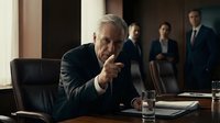 Senior Caucasian businessman pointing finger in boardroom meeting with diverse team of professionals in background for corporate leadership concepts.