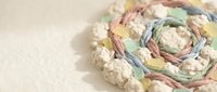 Colorful pastel yarn balls and skeins arranged in artistic composition on neutral background for crafting and knitting projects.