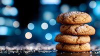 Stack of fresh homemade sugar coated ginger cookies on dark surface with sparkling bokeh lights creating magical holiday atmosphere.