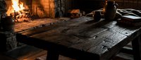 Rustic wooden table in front of a blazing fireplace, perfect for medieval, fantasy, or historical game and film production design backgrounds.