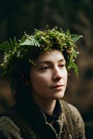 Young woman with natural fern crown in forest setting, earthy portrait with botanical headpiece for nature and wellness concepts.