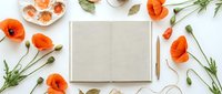 Flat lay of open blank notebook with pencil surrounded by red poppy flowers and paint palette on white background, top view.