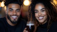 Joyful African American couple sharing drinks at night, genuine smiles and natural curly hair, warm lighting creates intimate atmosphere for lifestyle and relationship content.