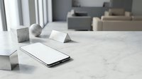 Smartphone with blank white screen lying on marble surface in modern interior, mockup for app or website display.