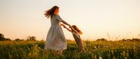 Mother and child playing together in golden sunset field, family bonding moment with warm evening light creating magical outdoor scene for lifestyle content.