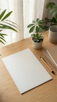 Minimalist workspace with blank paper, wooden pencils and green plants on bamboo desk near window with natural light for creative projects and office work.