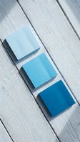 Three blue gradient color swatches arranged on white wooden planks showing light to dark blue tones for design and branding projects.