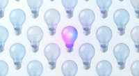 Bright pink lightbulb glowing among transparent bulbs on white background. Creative innovation concept for business ideas, leadership and inspiration.