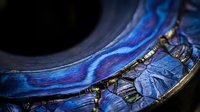 Luxurious blue silk fabric with golden embroidered details and ornate trim, showcasing rich textile craftsmanship and elegant decorative elements for premium design projects.