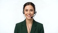 Professional young Caucasian businesswoman wearing headset smiling at camera in green blazer isolated on white background for customer service concepts.