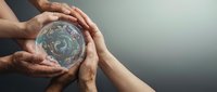 Diverse hands protecting Earth globe together showing unity and environmental responsibility for sustainable future and climate action.