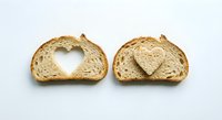 Fresh artisan bread slices with heart-shaped cutout and heart piece on white background, perfect for bakery marketing and food design projects.