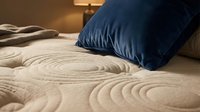 Zen garden sand pattern with navy blue pillow on bed, creating peaceful meditation and relaxation atmosphere for wellness and interior design projects.