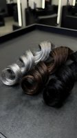 Hair color samples showing natural aging progression from black to silver gray arranged on salon chair for professional colorist consultation.