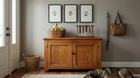 Cozy pet-friendly entryway with wooden cabinet, paw print wall art, wicker baskets and leashes. Warm home interior design for dog owners and animal lovers.