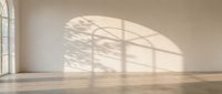 Empty minimalist room with natural sunlight casting window shadows on white wall and wooden floor for interior design and architecture projects.
