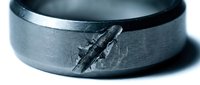 Tungsten carbide men's wedding band with airplane engraving on brushed metal surface, masculine jewelry design for aviation enthusiasts and pilots.