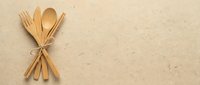 Wooden cutlery set tied with twine on beige textured background, flat lay composition for dining, kitchen, and eco-friendly tableware design projects.