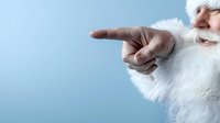 Senior Caucasian man with natural white beard pointing finger sideways against blue background, cropped view showing partial face and hand gesture.