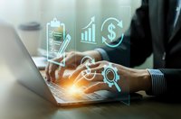 Business professional using laptop with digital financial icons overlay showing growth charts, dollar signs and analytics symbols for modern finance technology.