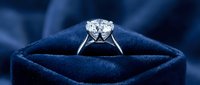 Elegant diamond engagement ring in luxury blue velvet jewelry box with dramatic lighting for wedding and proposal concepts.