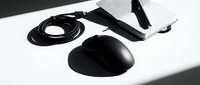 Black computer mouse with USB cable and lanyard on white background isolated for tech design projects and office equipment presentations.