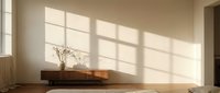 Minimalist wooden table with decorative branch in sunlit room with geometric window shadows on neutral wall creating peaceful interior atmosphere.