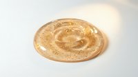 Swirl of creamy beige paste with golden sparkles on white background, isolated for cosmetic, skincare, or food product packaging design use.
