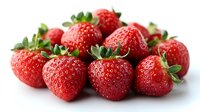 Fresh ripe strawberries with green leaves isolated on white background, macro shot showing detailed texture of juicy red berries for food photography.