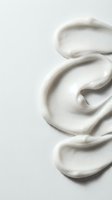 Creamy white lotion or moisturizer swirl texture on clean background for skincare and beauty product advertising campaigns.