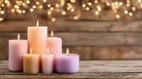 Colorful pillar candles burning on rustic wooden surface with warm bokeh lights creating cozy atmospheric ambiance for relaxation and home decor.